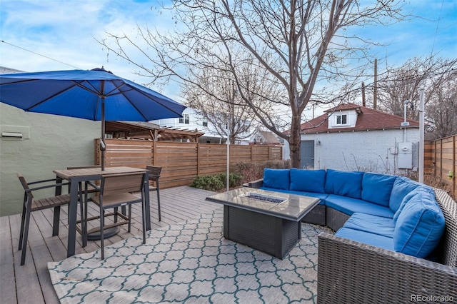 view of patio with outdoor dining space, an outdoor living space with a fire pit, fence, and a wooden deck