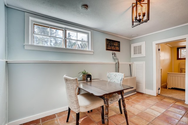 tiled dining area featuring a textured ceiling, crown molding, and radiator