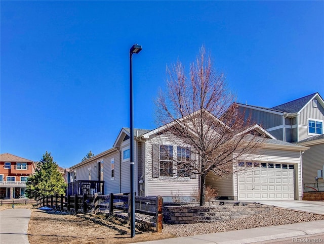 view of front of home with a garage, driveway, and fence