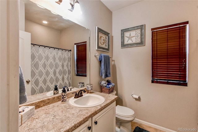 bathroom featuring curtained shower, toilet, vanity, and baseboards