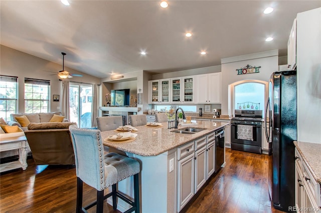 kitchen with range with gas cooktop, open floor plan, freestanding refrigerator, and a sink