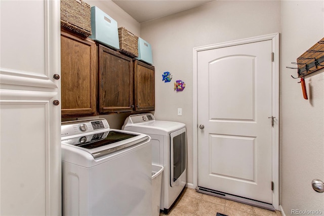 laundry room featuring baseboards, cabinet space, and washer and clothes dryer