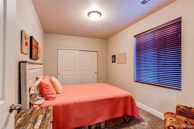 bedroom featuring visible vents, a textured ceiling, a closet, carpet, and baseboards