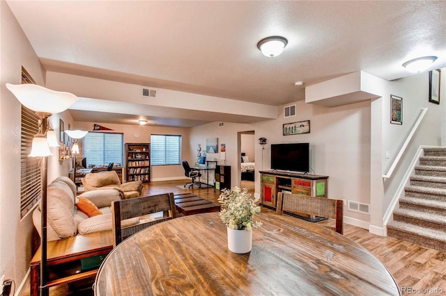 dining area with visible vents, wood finished floors, and stairway