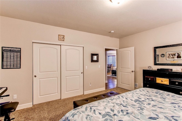 bedroom with a closet, baseboards, a textured ceiling, and carpet flooring