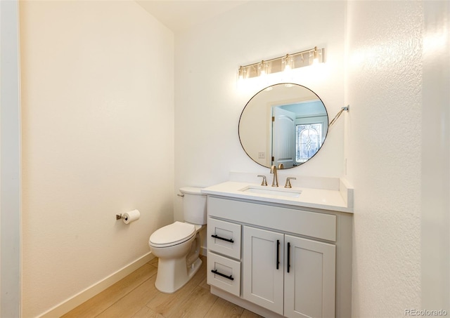 bathroom with vanity, hardwood / wood-style flooring, and toilet