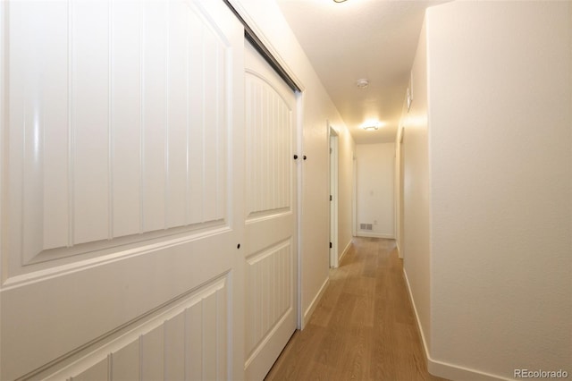 corridor with light hardwood / wood-style floors