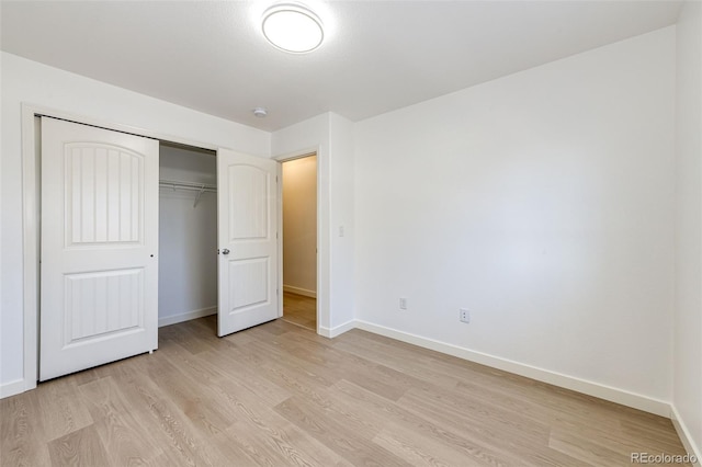 unfurnished bedroom with light wood-type flooring and a closet