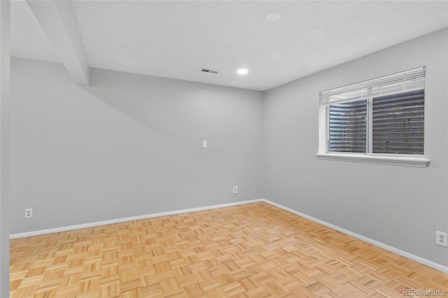 empty room with visible vents, baseboards, and a textured ceiling