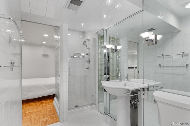 full bath with visible vents, tile walls, toilet, a stall shower, and ensuite bath