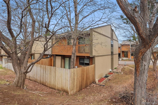 view of side of property featuring fence and stucco siding