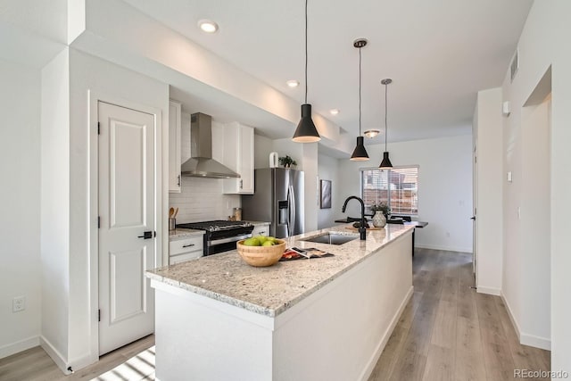 15325 W 69th Dr, Arvada, CO 80007 - kitchen featuring wall chimney exhaust hood, black range with gas cooktop, a sink, stainless steel refrigerator with ice dispenser, and white cabinets