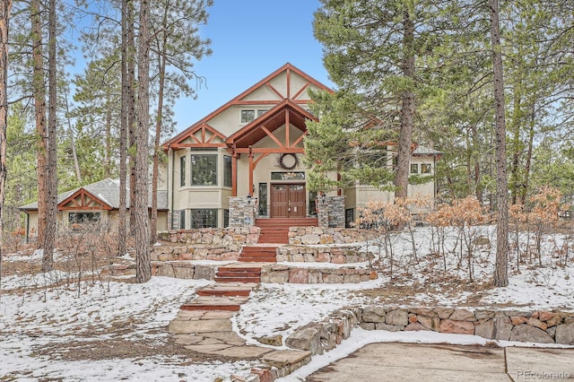 tudor home featuring stone siding and stucco siding