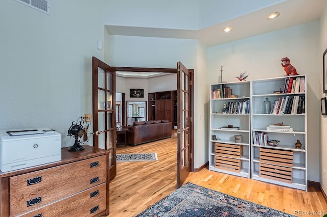 home office with wood finished floors, french doors, visible vents, and baseboards