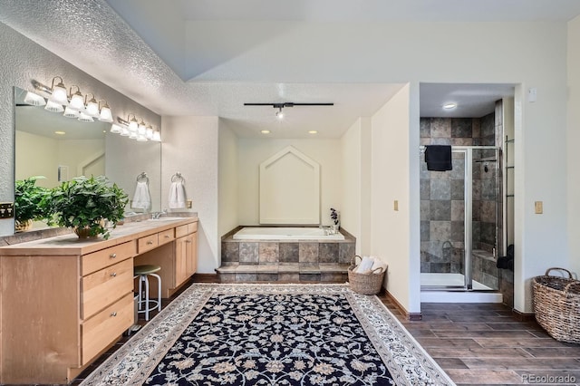 full bath with vanity, baseboards, wood finish floors, a shower stall, and a bath