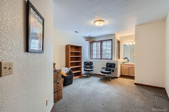 living area featuring visible vents, a textured ceiling, carpet, baseboards, and a textured wall