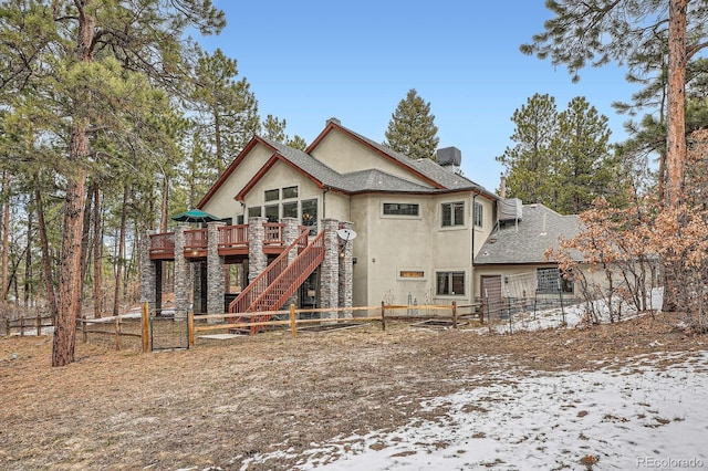 back of house featuring a shingled roof, fence, stairway, stucco siding, and a deck