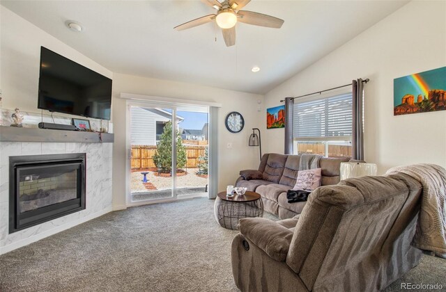 2734 Grand Prix Ct, Colorado Springs, CO 80922 - carpeted living room with lofted ceiling, a glass covered fireplace, a ceiling fan, healthy amount of natural light, and baseboards