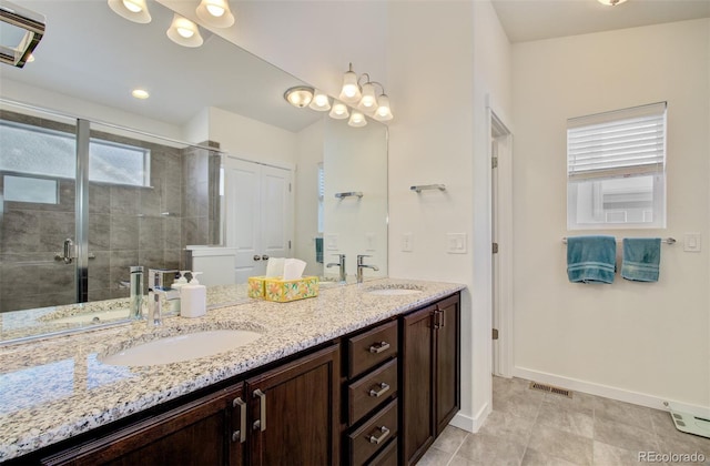 2734 Grand Prix Ct, Colorado Springs, CO 80922 - full bath featuring double vanity, baseboards, plenty of natural light, and a stall shower