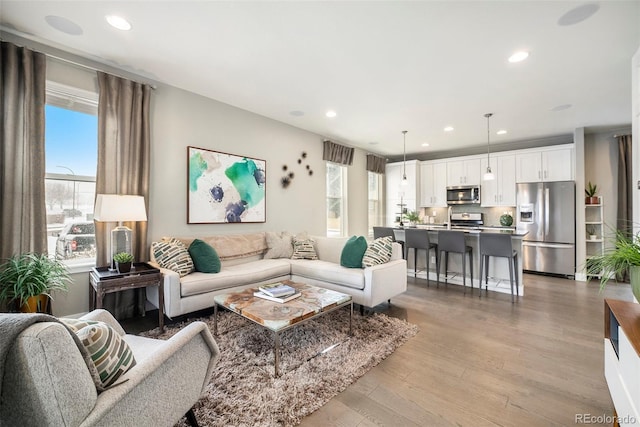 living area featuring recessed lighting, light wood-type flooring, and a healthy amount of sunlight