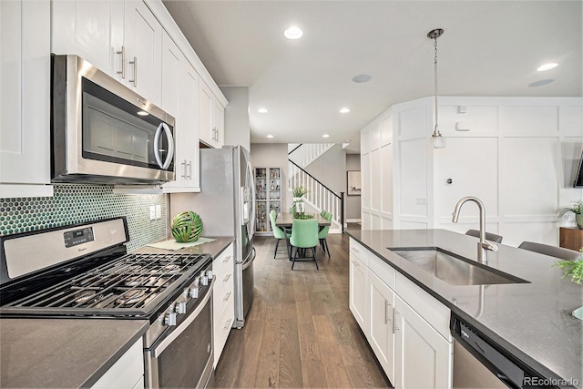 kitchen with white cabinetry, appliances with stainless steel finishes, pendant lighting, and a sink