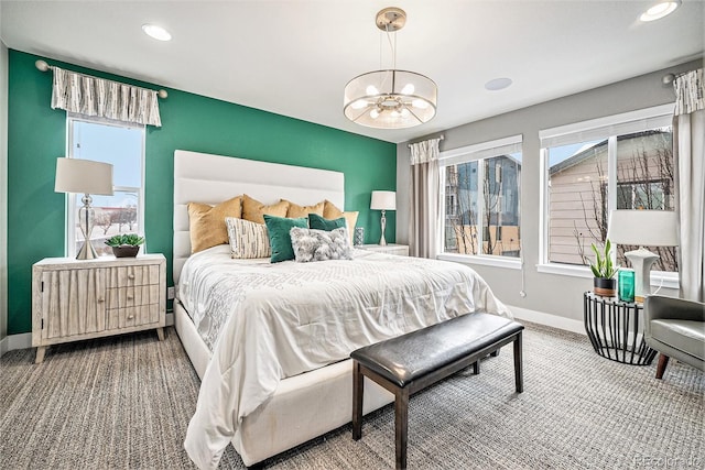 bedroom featuring a notable chandelier, radiator heating unit, multiple windows, and baseboards