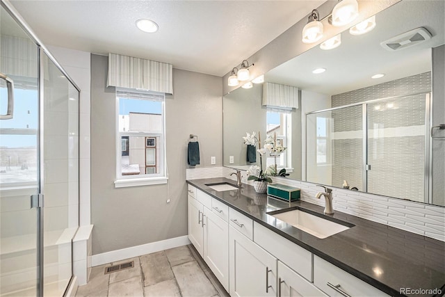 full bath with a shower stall, visible vents, and a sink