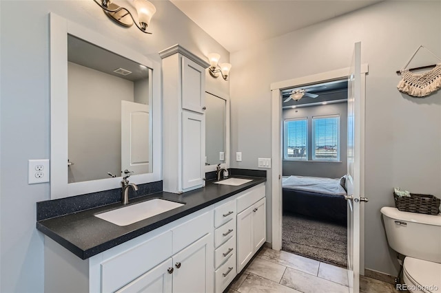 full bath featuring visible vents, double vanity, a sink, and toilet