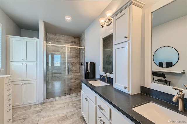 bathroom with double vanity, a stall shower, and a sink