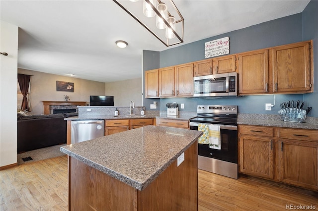 9684 W Long Dr, Littleton, CO 80123 - kitchen featuring appliances with stainless steel finishes, a sink, open floor plan, and light wood finished floors