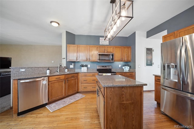 9684 W Long Dr, Littleton, CO 80123 - kitchen featuring stainless steel appliances, light wood finished floors, a peninsula, a kitchen island, and dark stone countertops