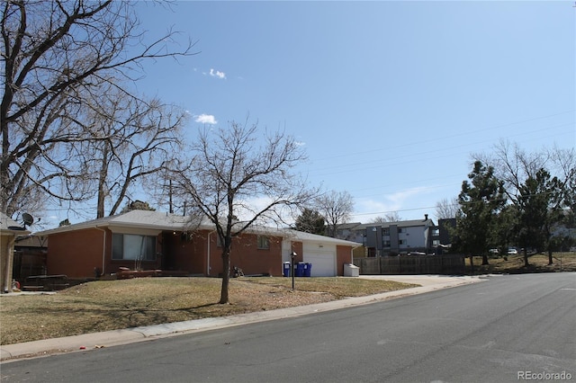 single story home featuring a front yard, fence, a garage, and driveway