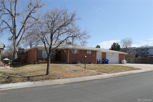 ranch-style house featuring a garage, driveway, and fence