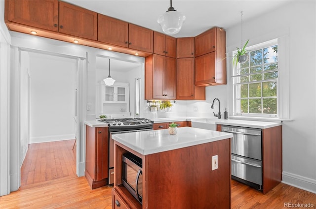 1038 E 4th Ave, Denver, CO 80218 - kitchen with appliances with stainless steel finishes, a sink, light countertops, and light wood-style flooring