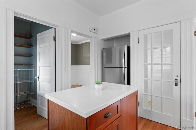 1038 E 4th Ave, Denver, CO 80218 - kitchen featuring freestanding refrigerator, light wood finished floors, light countertops, a center island, and brown cabinetry