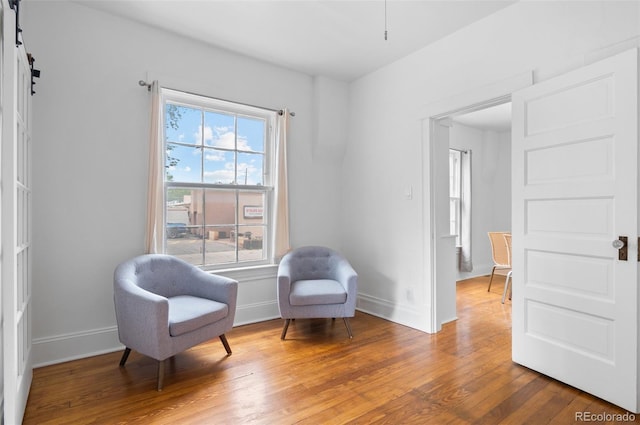 1038 E 4th Ave, Denver, CO 80218 - sitting room with wood finished floors, baseboards, and a barn door