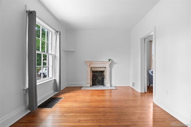 1038 E 4th Ave, Denver, CO 80218 - unfurnished living room with light wood-style floors, a high end fireplace, and baseboards