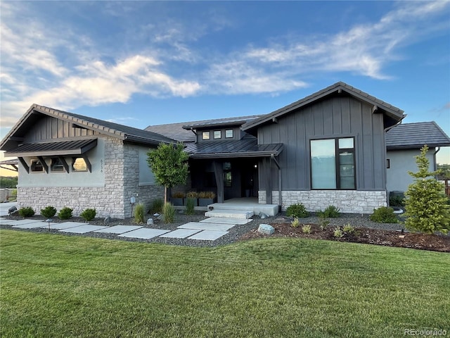 6736 S Flanders Ct, Aurora, CO 80016 - view of front of house featuring stone siding, a front yard, and board and batten siding