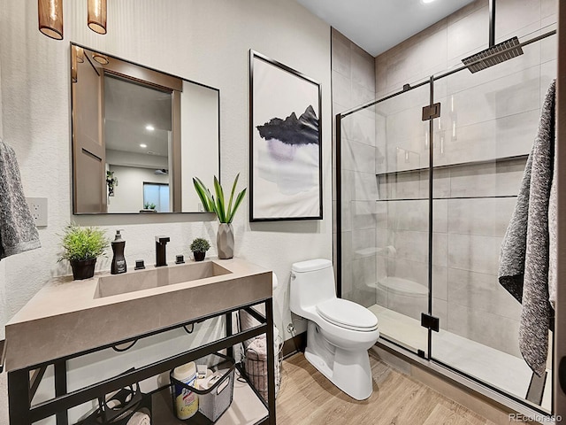 6736 S Flanders Ct, Aurora, CO 80016 - full bathroom with toilet, wood finished floors, vanity, a shower stall, and a textured wall