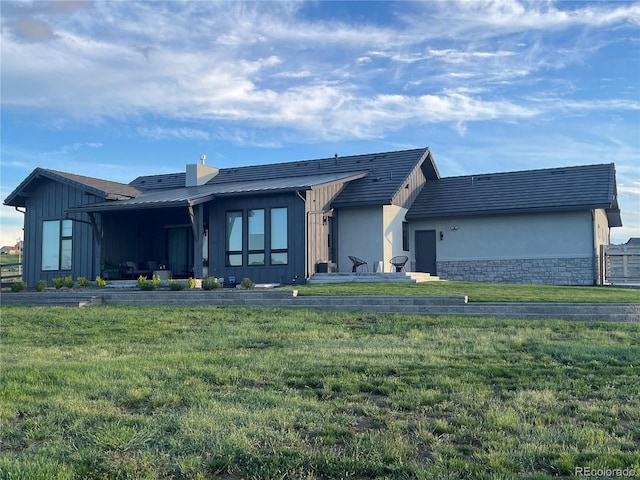 6736 S Flanders Ct, Aurora, CO 80016 - view of front facade featuring a front lawn, stone siding, board and batten siding, and stucco siding