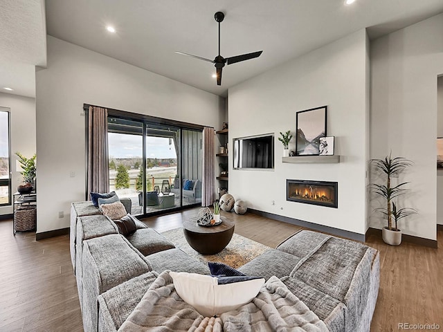 6736 S Flanders Ct, Aurora, CO 80016 - living area featuring a ceiling fan, a high ceiling, a glass covered fireplace, recessed lighting, and wood finished floors