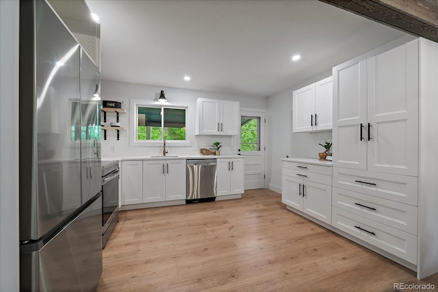 116 Monarch St, Louisville, CO 80027 - kitchen featuring stainless steel appliances, open shelves, white cabinetry, light wood-style flooring, and recessed lighting