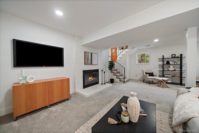 116 Monarch St, Louisville, CO 80027 - living room with light colored carpet, a glass covered fireplace, stairs, baseboards, and recessed lighting