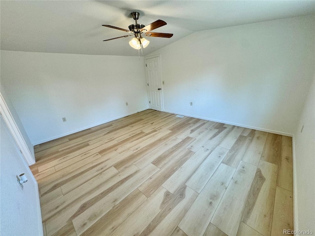 empty room featuring ceiling fan, light hardwood / wood-style floors, and vaulted ceiling