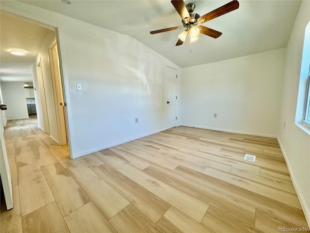 empty room featuring light hardwood / wood-style flooring, ceiling fan, and vaulted ceiling