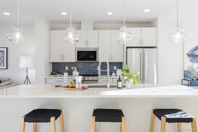 kitchen featuring a sink, white cabinetry, decorative backsplash, and high end fridge