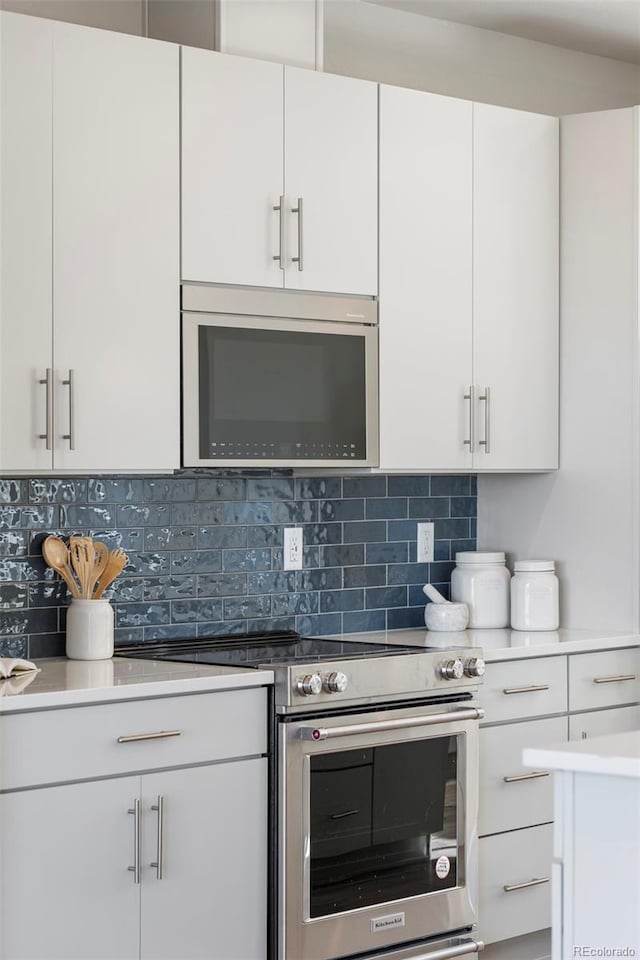 kitchen featuring backsplash, appliances with stainless steel finishes, white cabinets, and light countertops