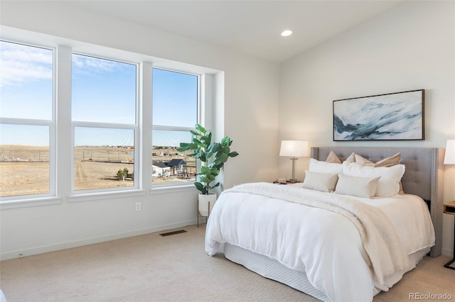 bedroom with light carpet, multiple windows, and visible vents