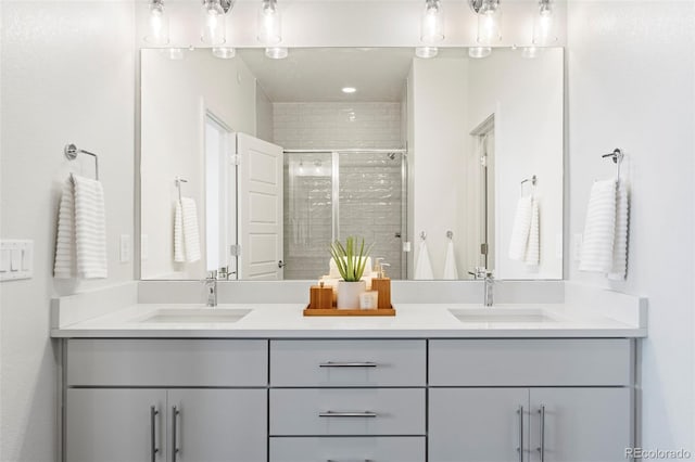 bathroom with double vanity, a sink, and a shower stall