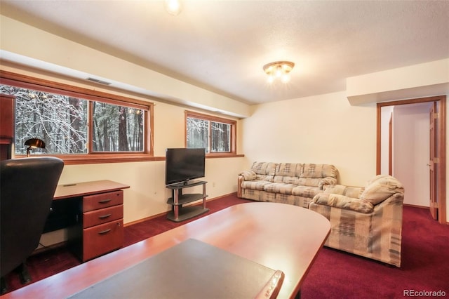 living area featuring a desk and dark colored carpet